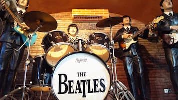 Een standbeeld van The Beatles die optreden op een podium, met een bakstenen muur op de achtergrond.