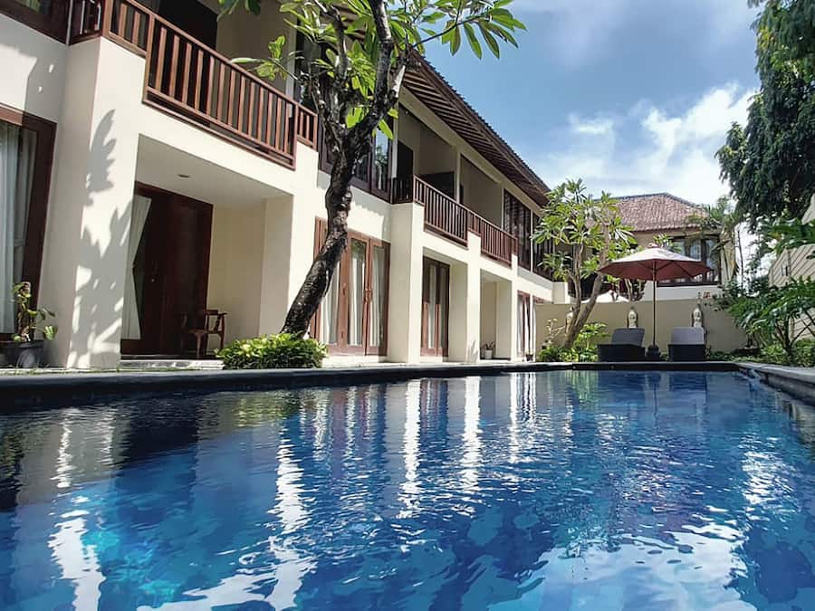 Una piscina al aire libre, sillones reclinables de piscina