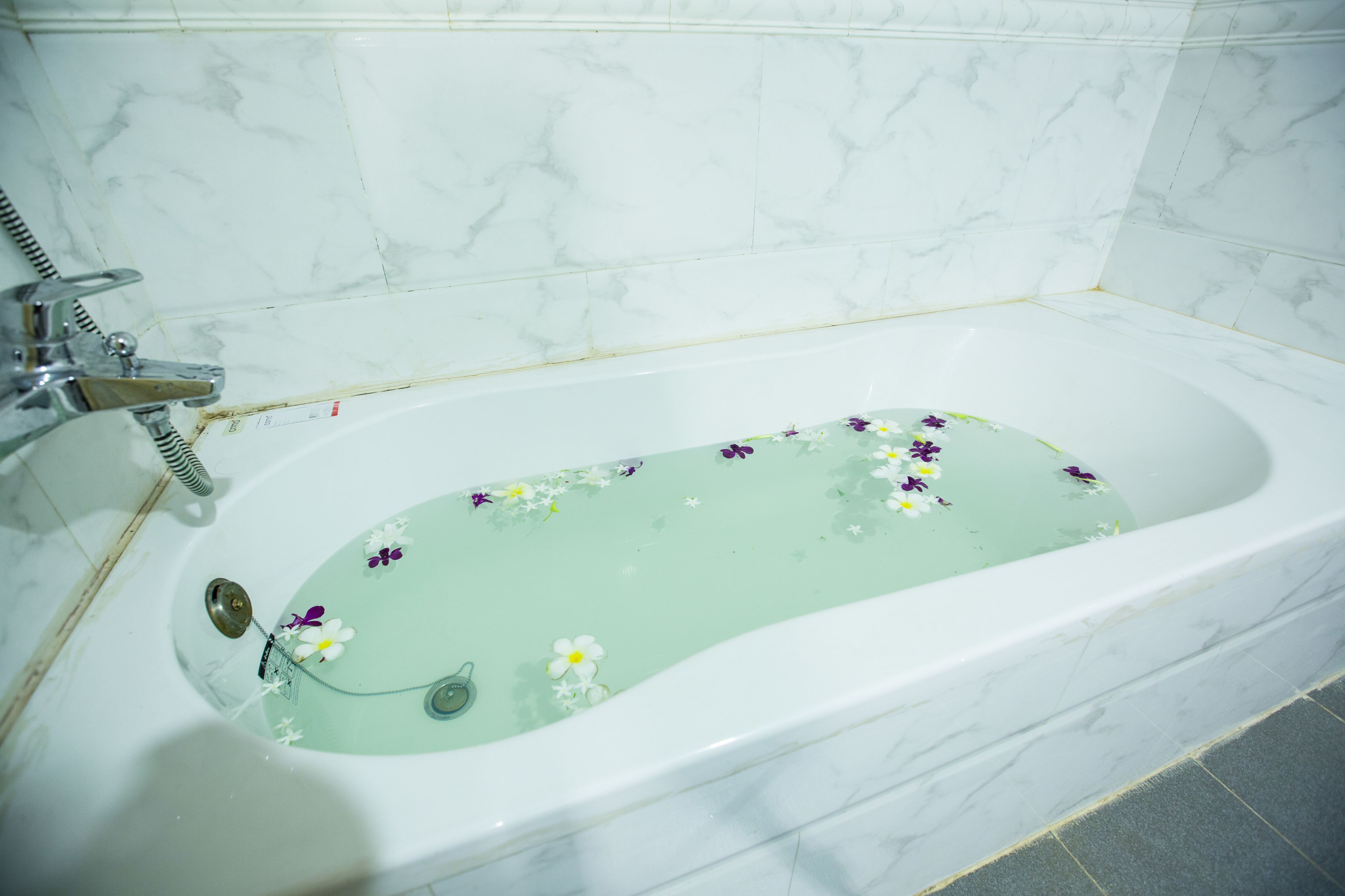 A bathtub with floral decorations and a shower head.