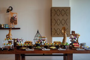 A buffet table with various food items and a decorative bird sculpture.