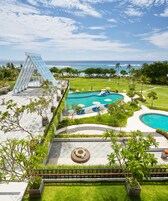 Ein Resort mit großzügigem Poolbereich, einer Glasbrücke und Meerblick.