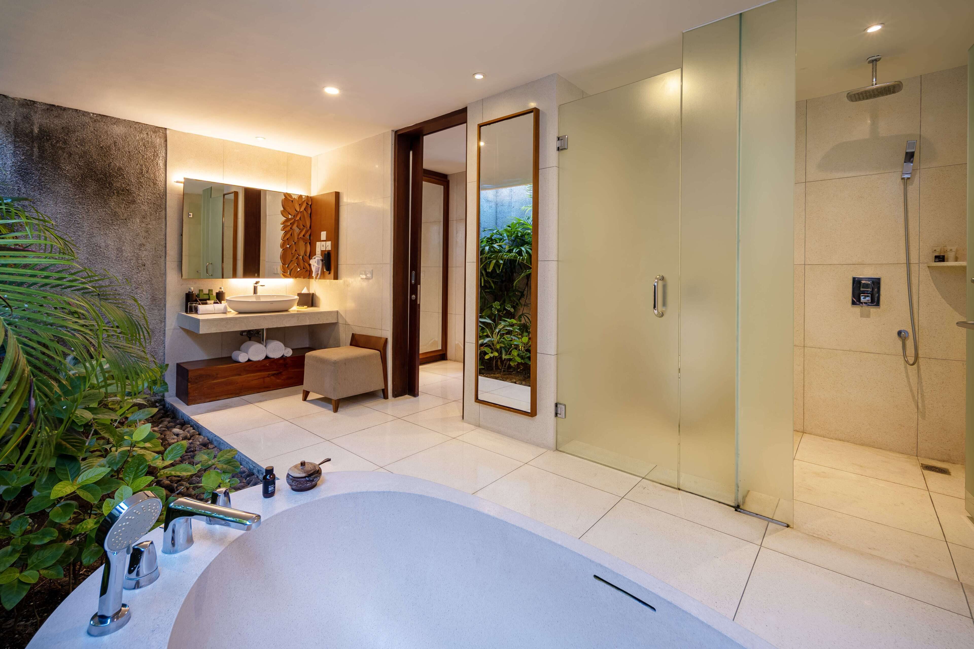 A modern bathroom with a large bathtub, a separate shower area, and a vanity with a sink and mirror.