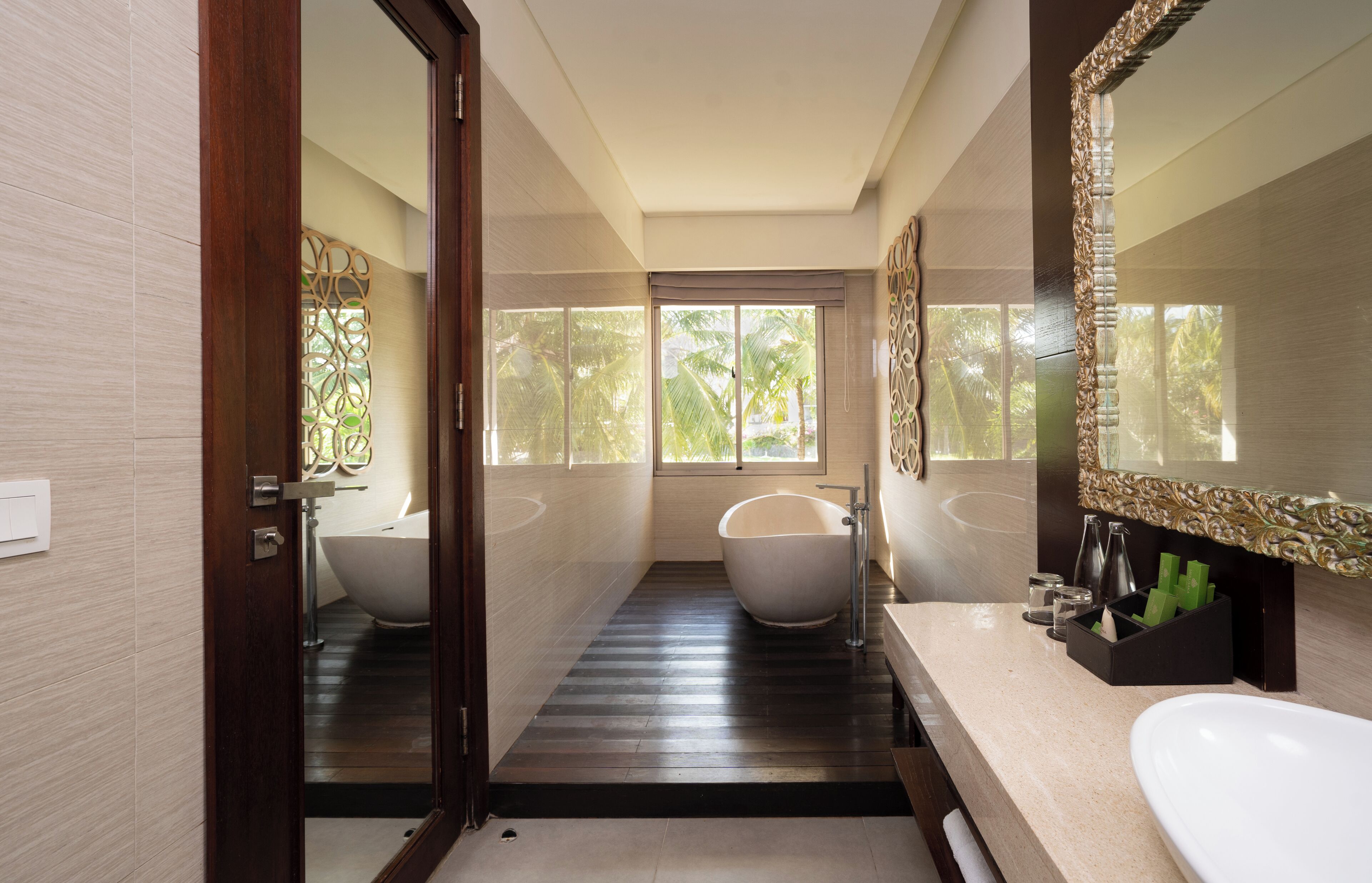 A modern bathroom with a bathtub, a large mirror, and a sink.