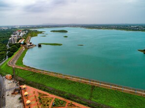 Eine Vogelperspektive einer Küstenregion mit einer Brücke, Grünflächen und Gebäuden entlang des Ufers.