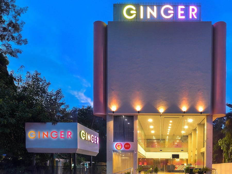 A building with a prominent 'GINGER' sign at the top and entrance, featuring a modern design with large windows and a flat roof.