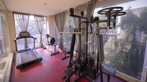 A gym with a treadmill, weight bench, and various exercise machines. - Hotel Clarks Collection Bhavnagar (Bhavnagar)