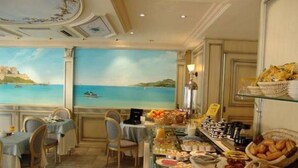 A dining area with a buffet, chairs, and a view of the sea.