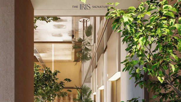 A modern hotel corridor with a marble floor, potted plants, and a seating area with tables and chairs. - The IRIS Signature Hotel & Spa (Can Tho)