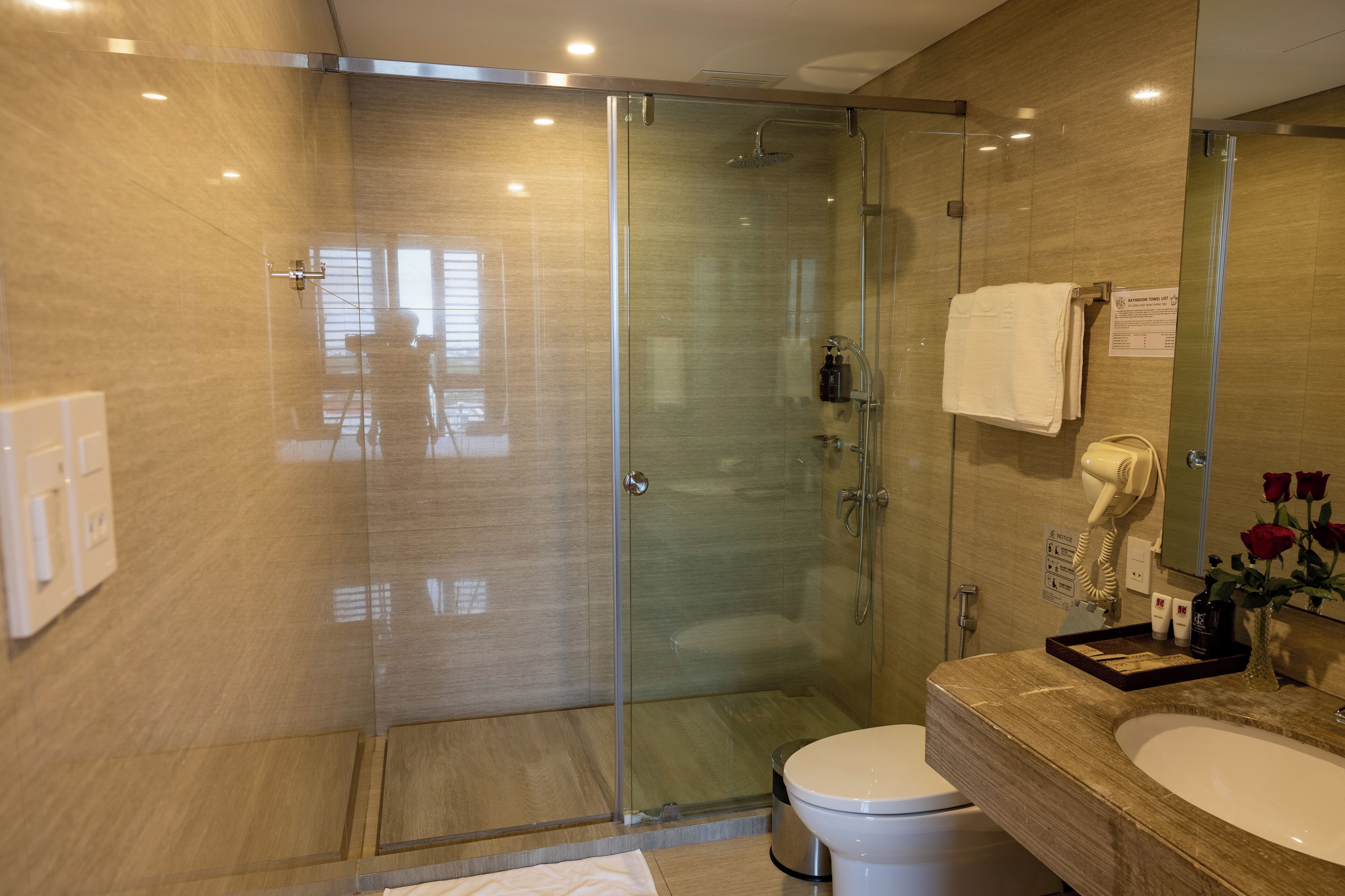 A modern bathroom with a glass-enclosed shower, a vanity with a sink, and a toilet.