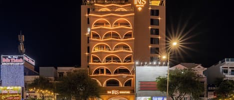 A multi-story hotel with a prominent sign reading 'The Iris Signature.'