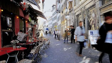 A cobblestone street with outdoor seating and a restaurant.