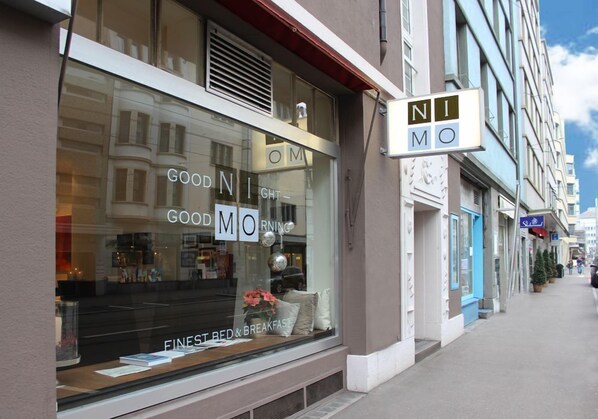 Un escaparate con un amplio ventanal que muestra los textos 'GOOD MORNING' y 'FINEST BED & BREAKFAST'.