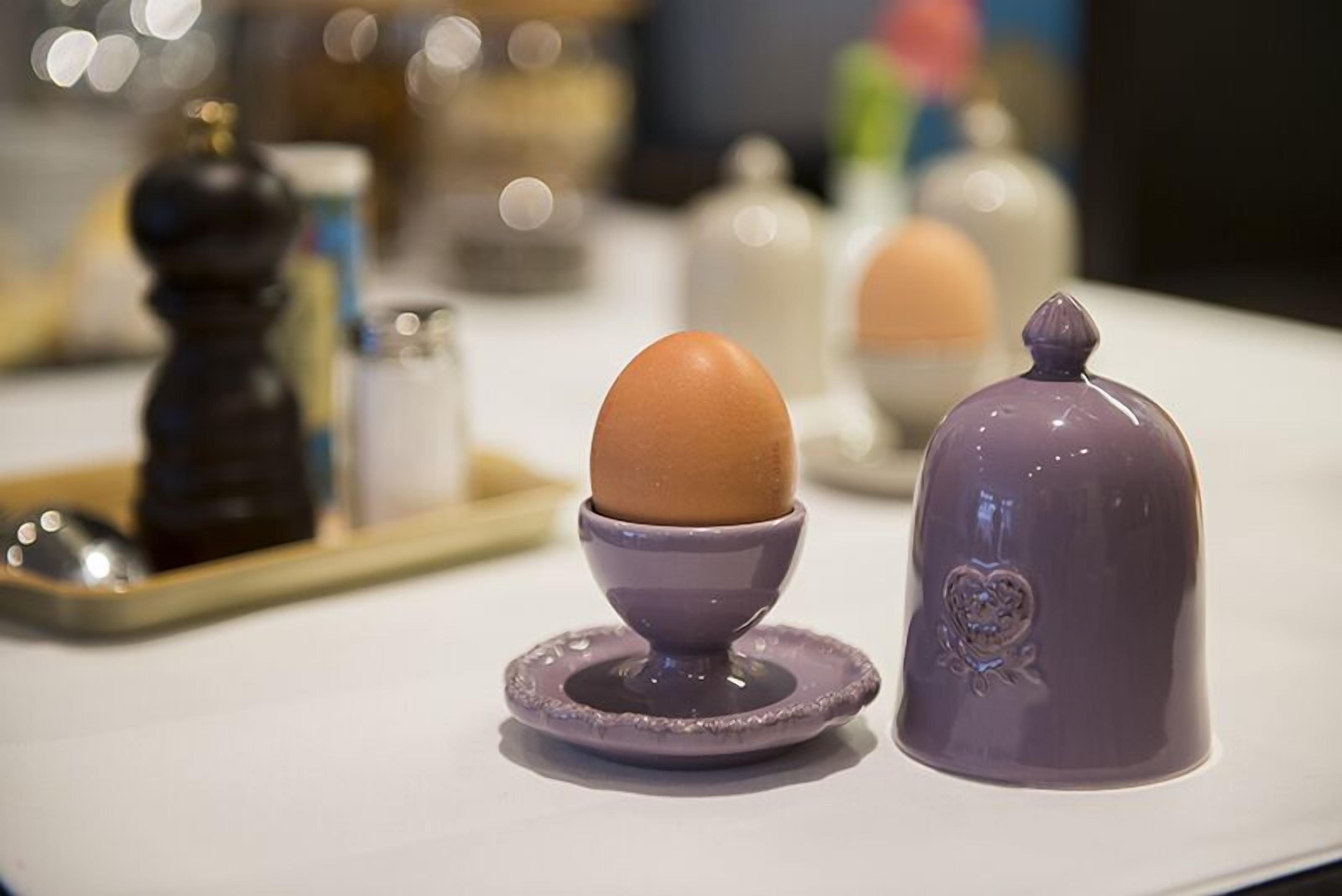 Una encimera de cocina con un soporte de cerámica para huevos y un salero.