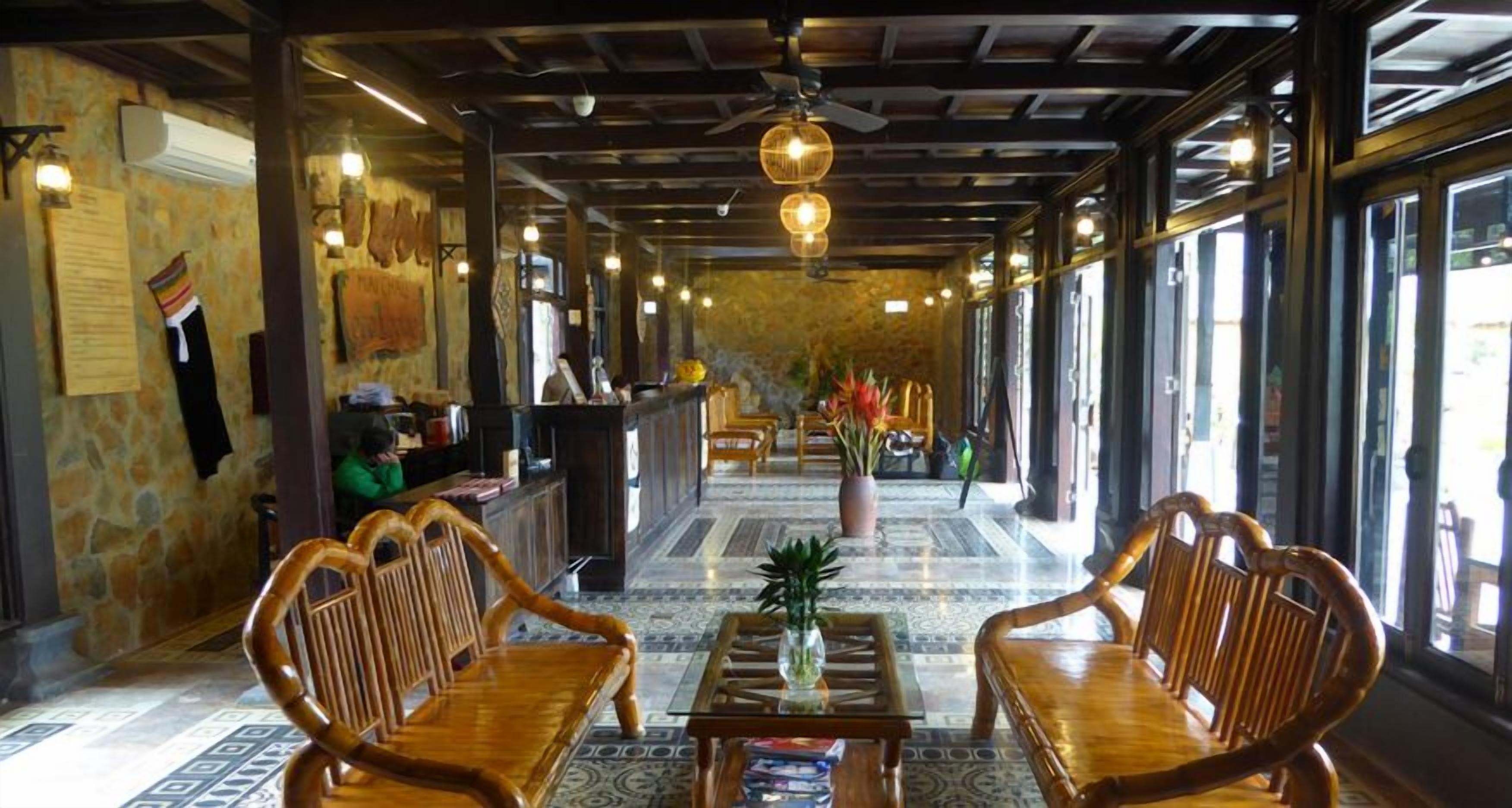 Un vestíbulo con mobiliario de madera, un mostrador de recepción y un suelo con diseño.