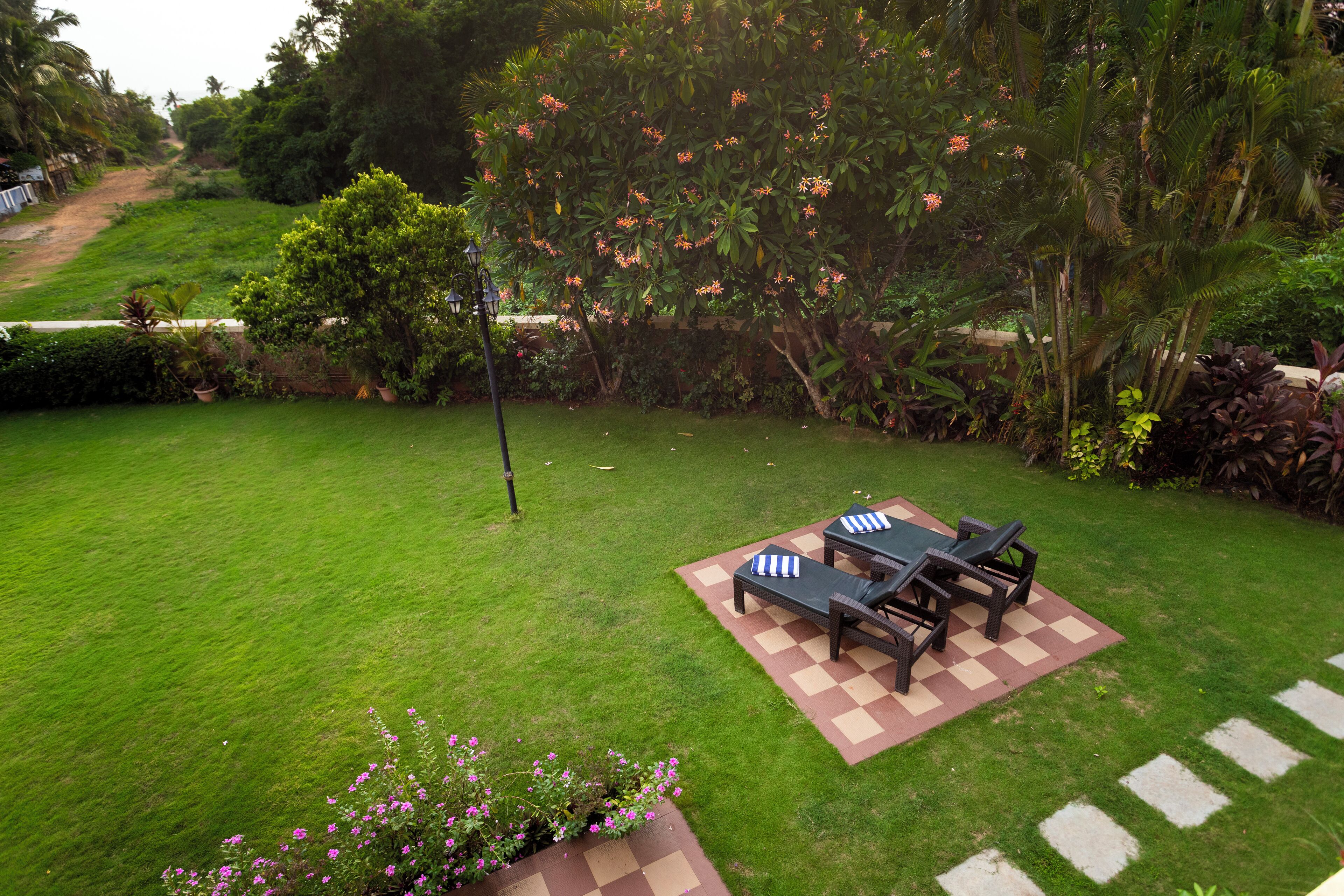 A well-maintained lawn with a checkered patio area and outdoor furniture.