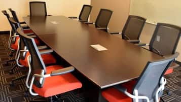 Una sala conferenze con un lungo tavolo, sei sedie e una lavagna.