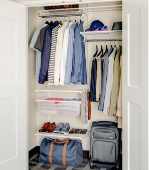 A walk-in closet with multiple shelves for clothing, a hanging rod for jackets, and a shoe rack. - TownePlace Suites Lawrence Downtown (Lawrence)