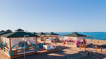 Playa privada, camas de playa (con cargo), camastros y sombrillas