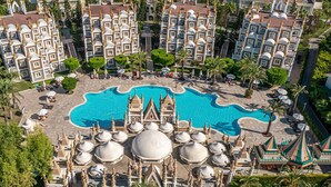 A large hotel complex with multiple buildings, a central swimming pool, and surrounding palm trees. - Kamelya Aishen Club (Manavgat)