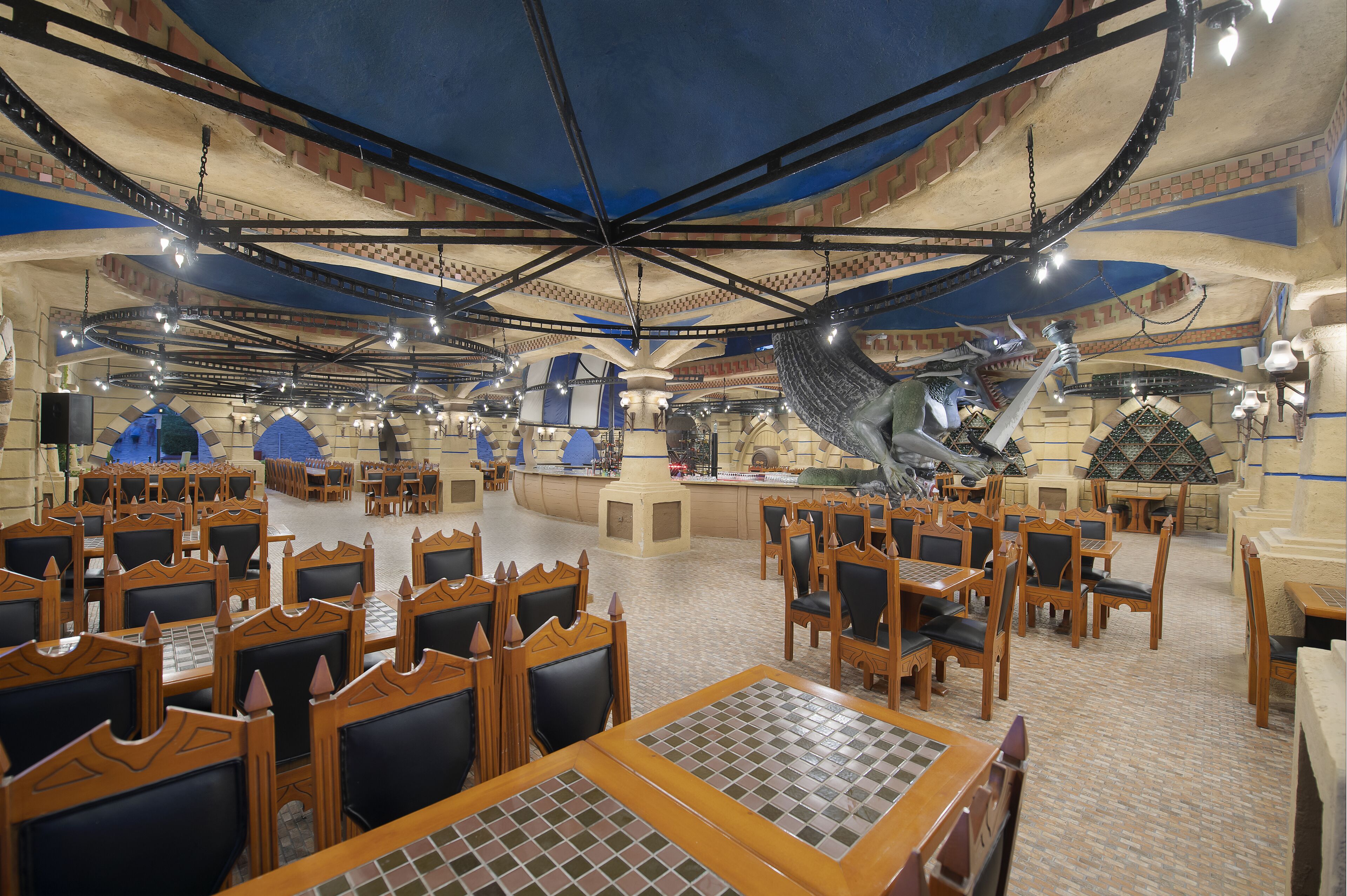 Un restaurante espacioso con techos altos, paredes de ladrillo visto y diversas opciones de asientos, incluyendo mesas y cabinas.