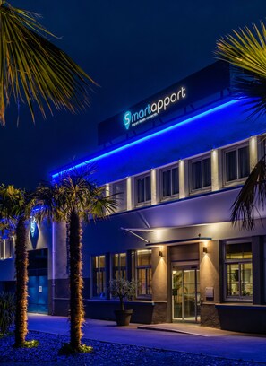 Un hotel moderno con un cartello ben visibile con la scritta "smartappart" e un ingresso luminoso.