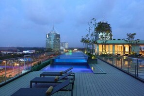 Una piscina al aire libre, sillones reclinables de piscina