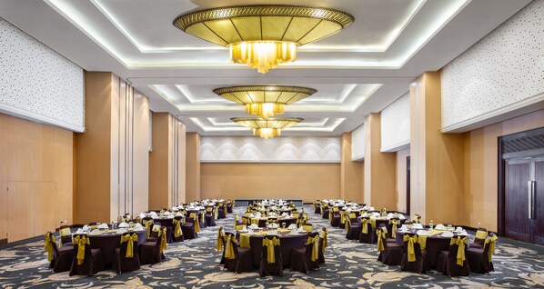 A large conference room with multiple round tables, each with chairs and table settings, featuring a modern chandelier and patterned carpet. - Hotel Santika Premiere Bintaro (South Tangerang)