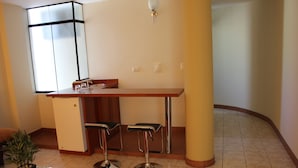 Una cocina compacta con barra, un refrigerador y una planta en maceta.
