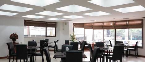 A conference room with a high ceiling, skylights, and large windows.