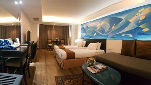 A hotel room with two beds, a sofa, a desk, and a television. - The Grand Sathorn (Bangkok)