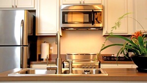 A modern kitchen with stainless steel appliances, including a refrigerator, microwave, and stove. - The Inn on Whitworth (Brookhaven)