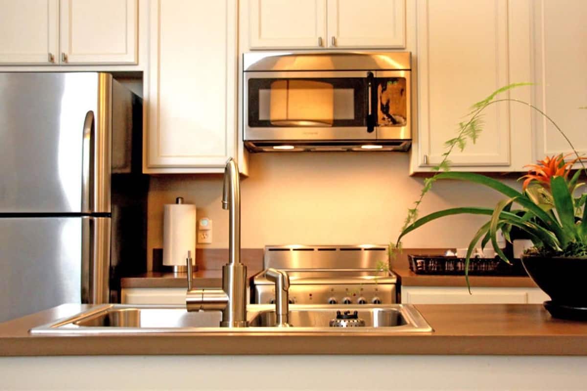 A modern kitchen with stainless steel appliances, including a refrigerator, microwave, and stove.