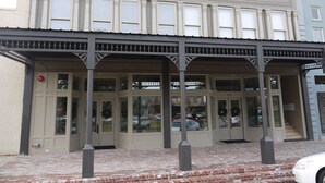 A building with a classic architectural style, featuring a covered entrance with columns and a brick-paved ground. - The Inn on Whitworth (Brookhaven)
