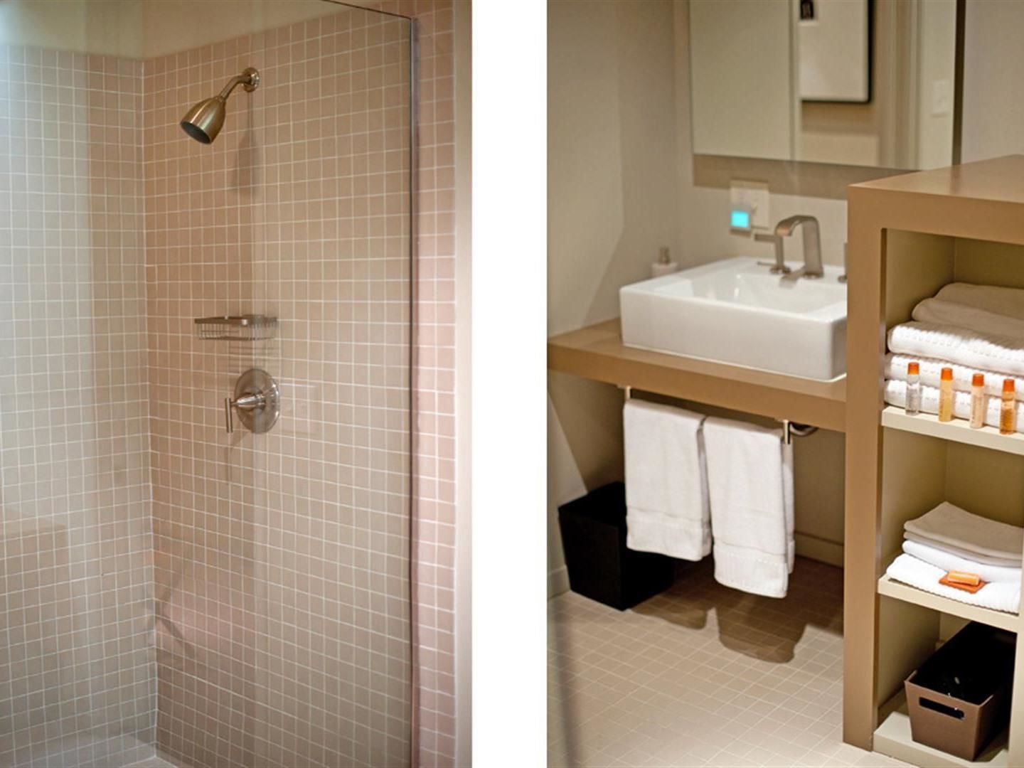 A bathroom with a shower, a sink, and a towel rack.