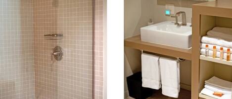 A bathroom with a shower, a sink, and a towel rack.