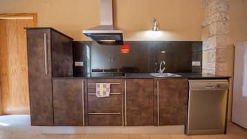 A kitchen with a built-in dishwasher, a stainless steel range hood, and a granite countertop.