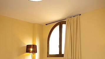 Un soggiorno con un divano, un tavolino, una televisione e una lampada.