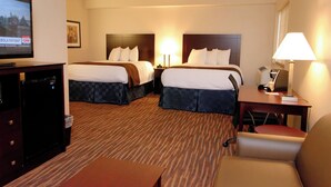 A hotel room with two beds, a television, a desk with a lamp, and a chair. - Cobblestone Inn & Suites - Fort Madison (Fort Madison)