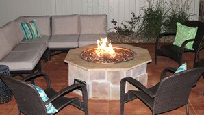 A fire pit surrounded by outdoor furniture, including a sofa and chairs, in a patio area. - Cobblestone Inn & Suites - Fort Madison (Fort Madison)