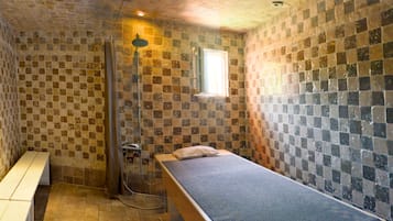 Cozy retreat with a single bed, bench, and shower area.