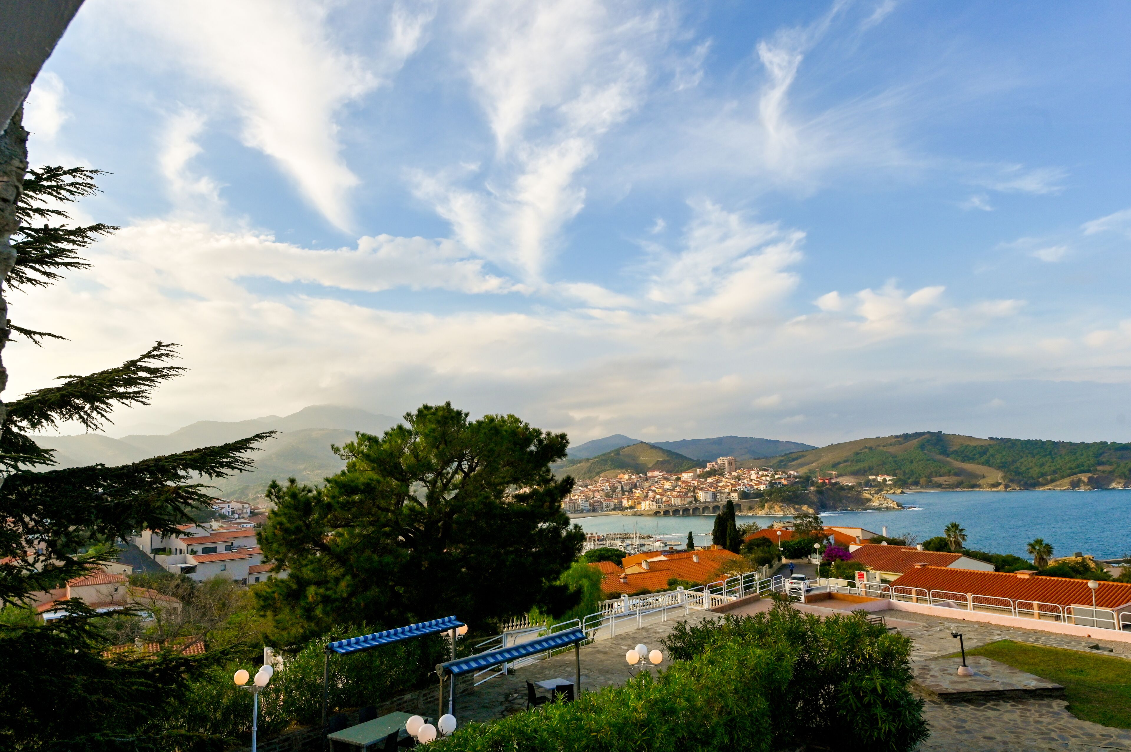A coastal town with a view of the sea and mountains in the background.