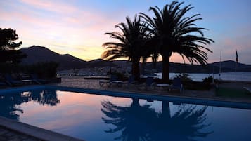 Una piscina al aire libre de temporada, sombrillas