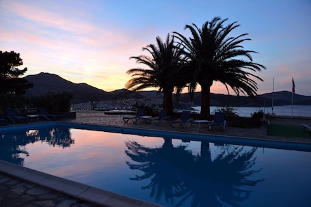Una piscina al aire libre de temporada, sombrillas