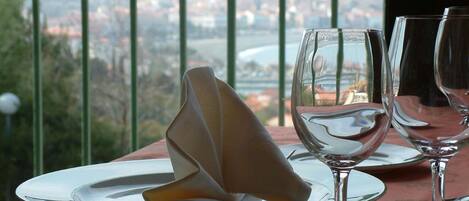 A dining table with a folded napkin, two wine glasses, and a plate set for a meal.