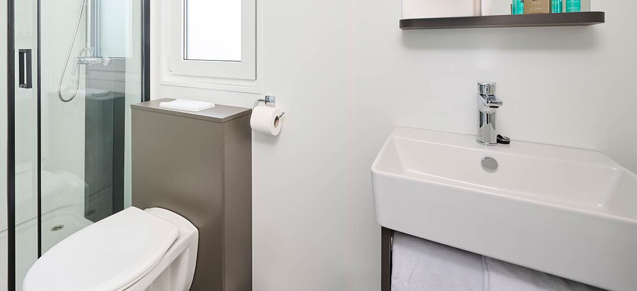 Un bagno con un water, una doccia e un lavandino.