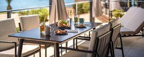 A dining table with chairs, a pitcher, a bowl of fruit, and a cup. - Aminess Planet Camping Holiday Homes Sirena (Novigrad)