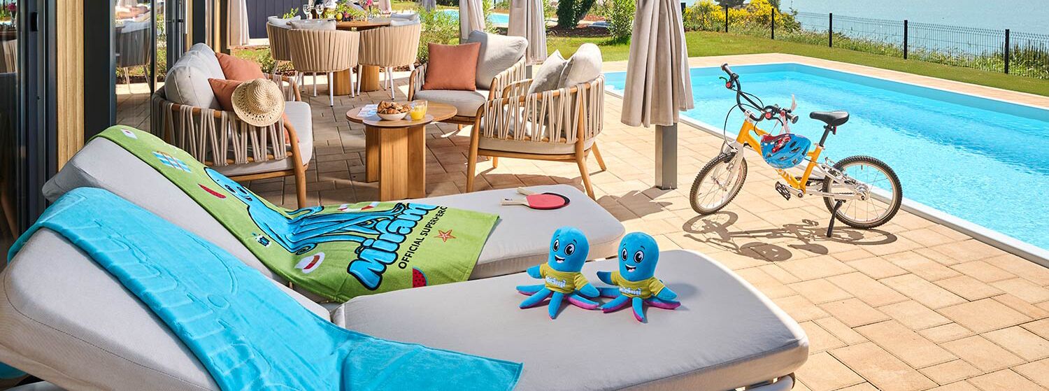 A poolside area with lounge chairs, a bicycle, and a view of the pool.