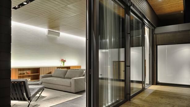 A modern interior with a grey sofa, a black chair, and a wooden floor. - Oranda Village (Rogaska Slatina)