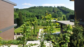 Ein modernes Gebäude mit Backsteinfassade, einem Dachgarten und Blick auf einen üppigen, grünen Hang.