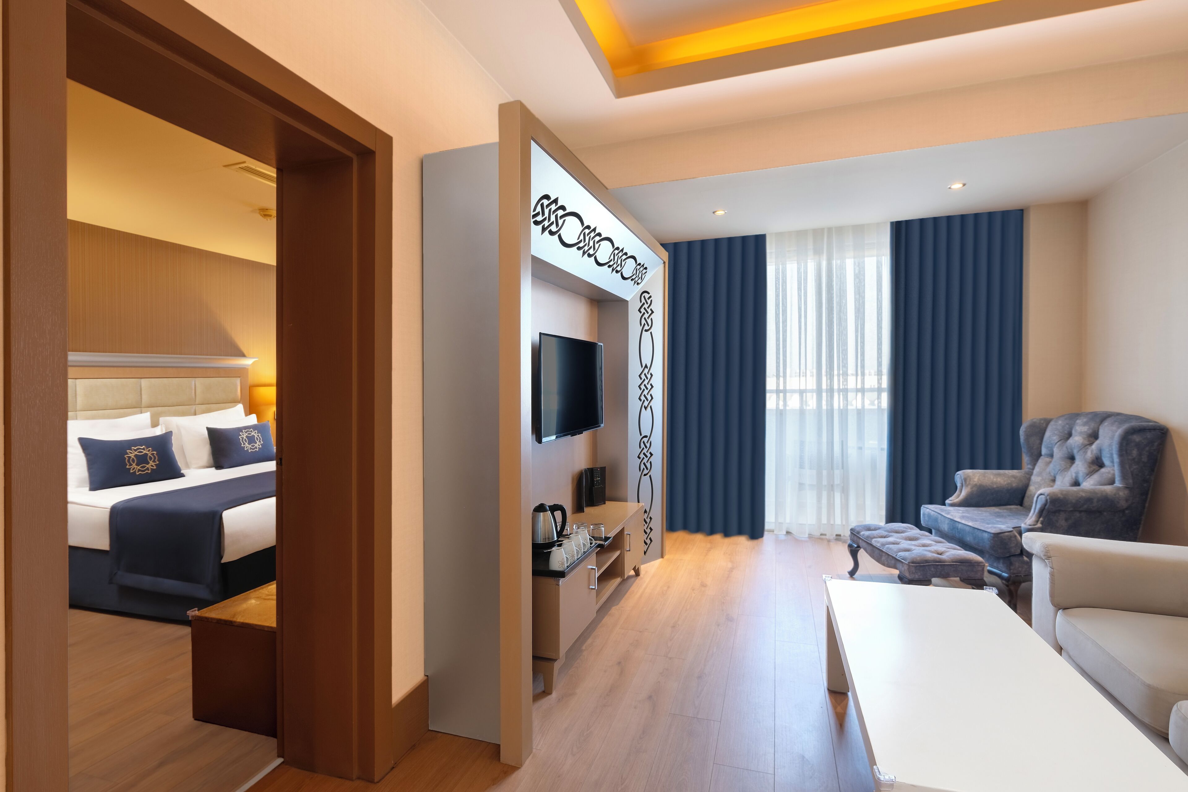 Una habitación de hotel con cama, televisor, escritorio, silla y sofá.